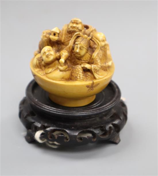 A Japanese ivory okimono netsuke of immortals, signed, wood stand